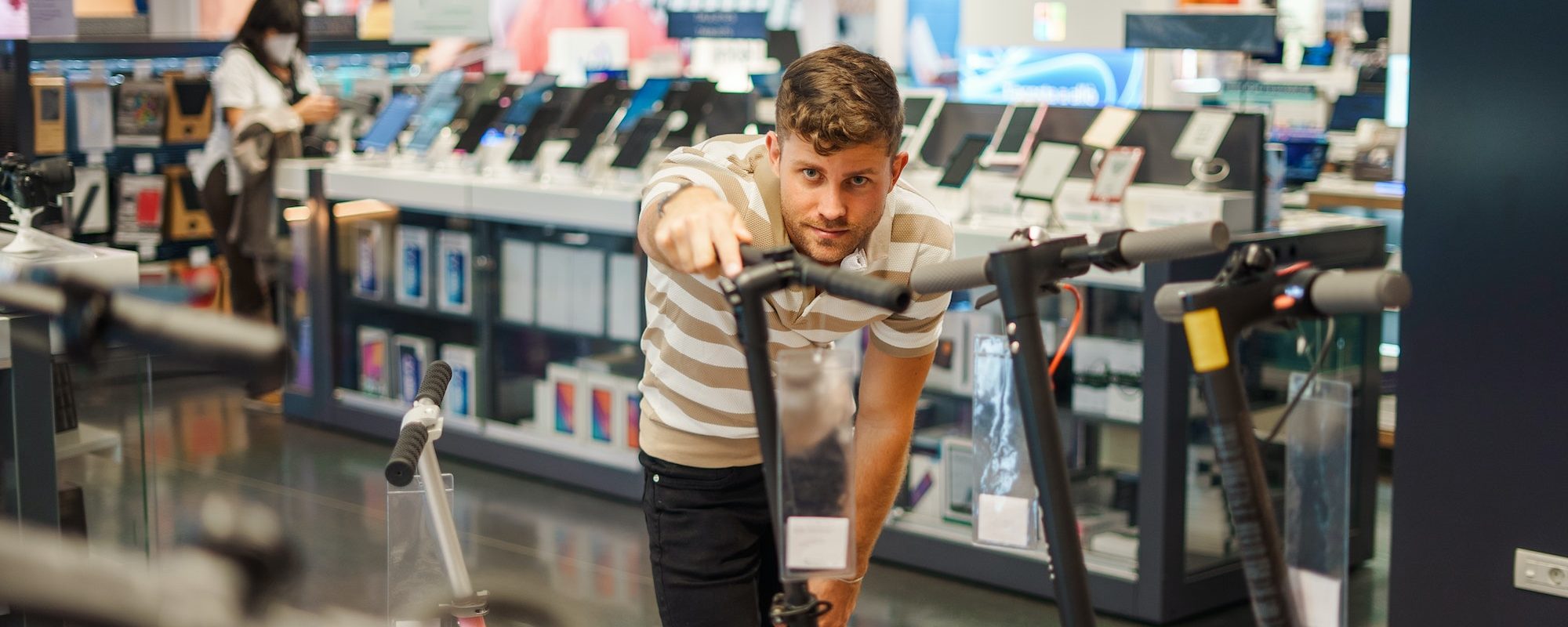 Man choosing electric scooter in store